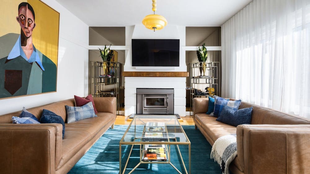 A colourful art deco inspired living room with opulent furniture and artwork.