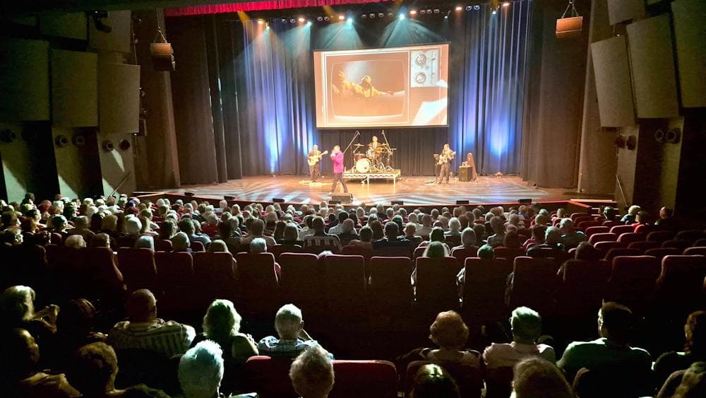 Performers on stage and a large audience